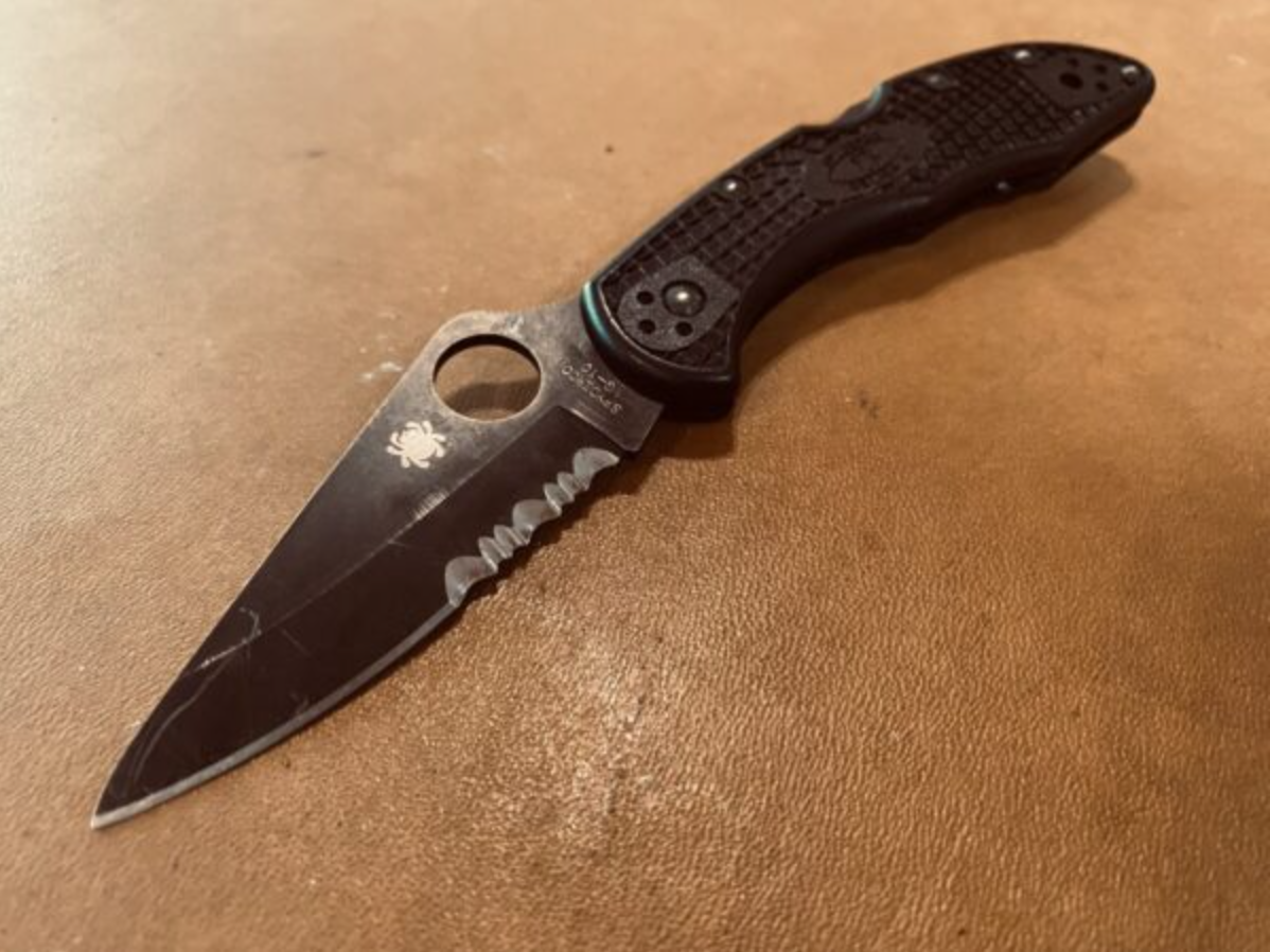 Spyderco Delica 4 folding EDC knife with a black partially serrated blade and textured handle.